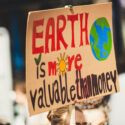 Earth is more valuable than money poster in a person hand